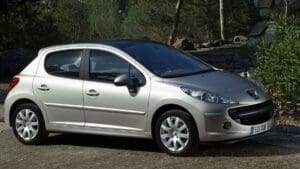 Peugeot 207 rouge en extérieur, présentant des problèmes fréquents à surveiller