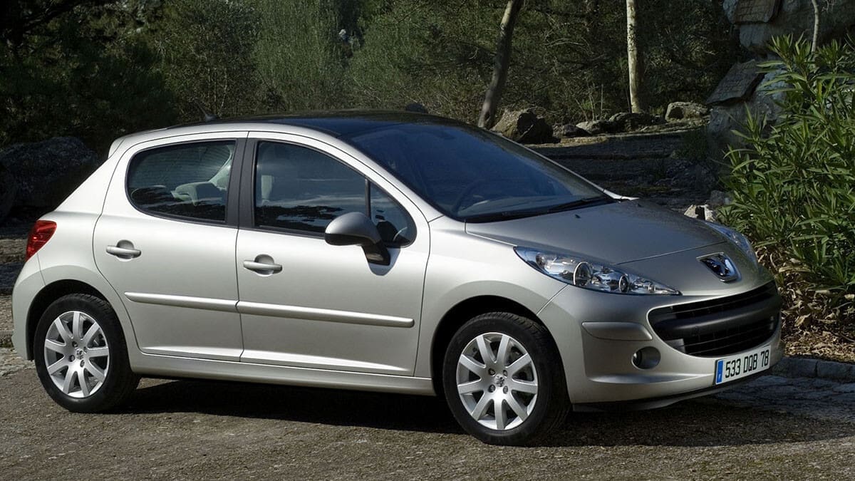 Peugeot 207 rouge en extérieur, présentant des problèmes fréquents à surveiller