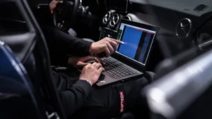 Ingénieur réalisant une reprogrammation moteur via logiciel sur ordinateur dans un atelier professionnel