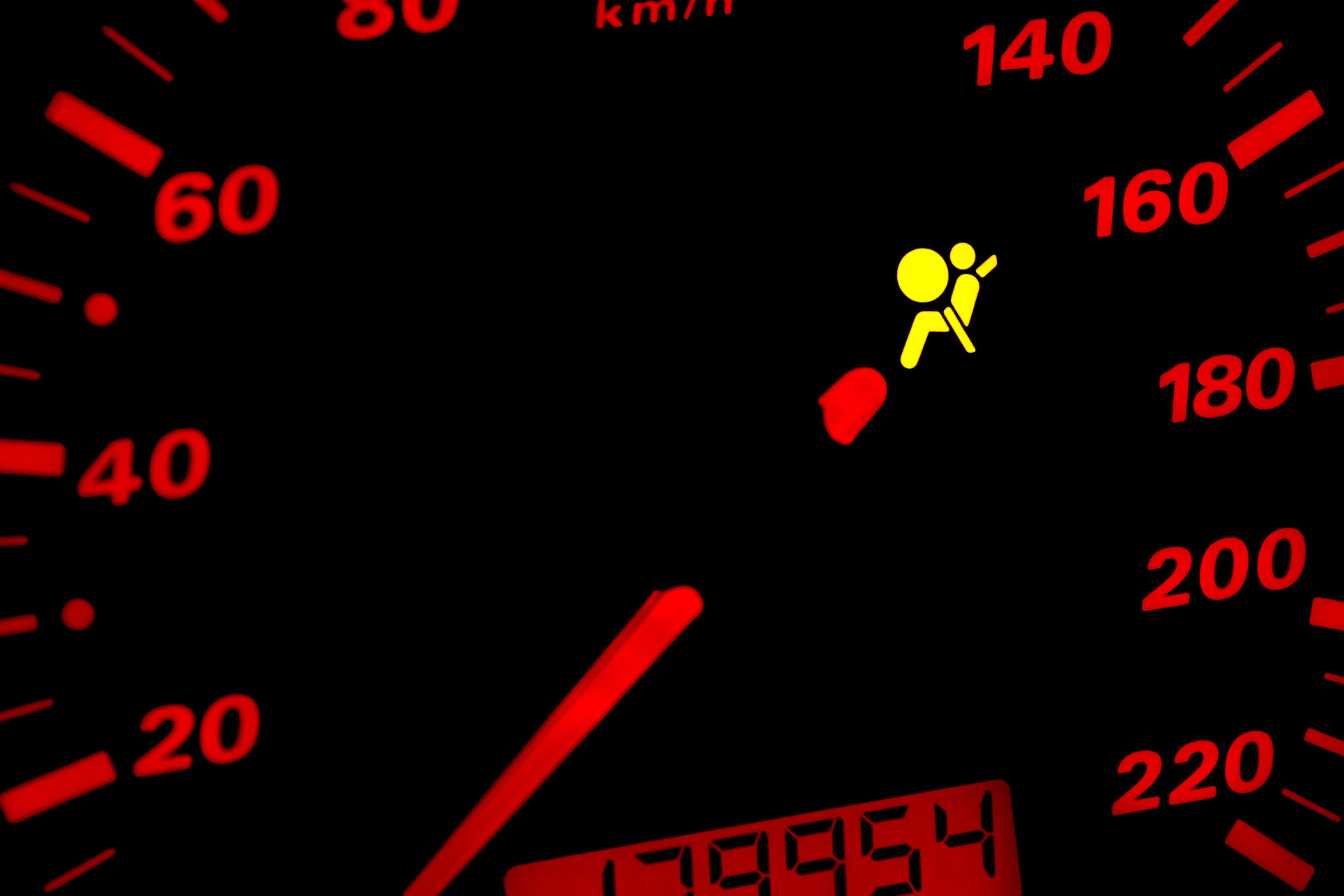 Voyant orange point d'exclamation allumé sur un tableau de bord de voiture, signifiant une alerte à ne pas ignorer