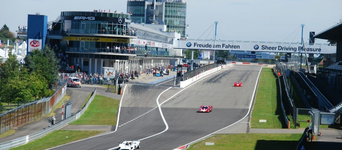 two red and white vehicles on race track during daytime