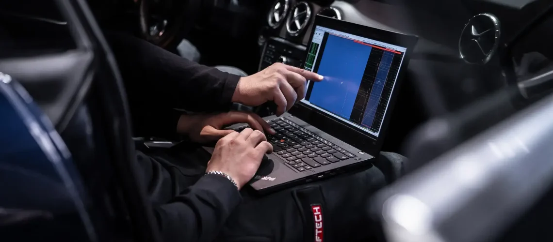 Ingénieur réalisant une reprogrammation moteur via logiciel sur ordinateur dans un atelier professionnel