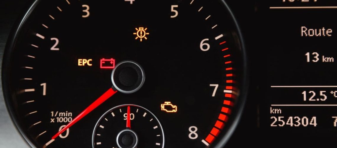 Voyant triangle orange avec point d'exclamation allumé sur tableau de bord de voiture